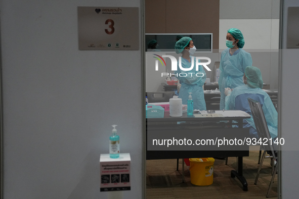 Health workers wearing a personal protective equipment (PPE) prepare at vaccination site inside the shopping mall in Bangkok on December 20,...