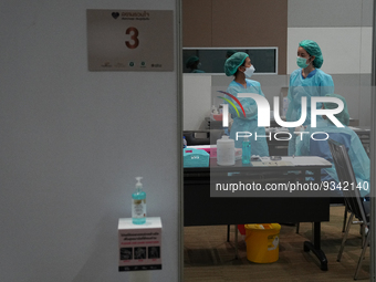 Health workers wearing a personal protective equipment (PPE) prepare at vaccination site inside the shopping mall in Bangkok on December 20,...