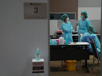 Health workers wearing a personal protective equipment (PPE) prepare at vaccination site inside the shopping mall in Bangkok on December 20,...