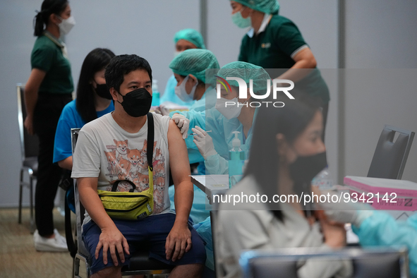 A health worker administers the COVID-19 vaccine to people at vaccination site inside the shopping mall in Bangkok on December 20, 2022 in B...