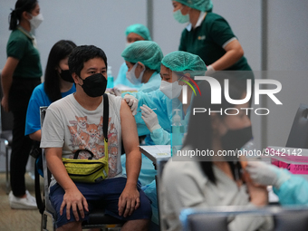 A health worker administers the COVID-19 vaccine to people at vaccination site inside the shopping mall in Bangkok on December 20, 2022 in B...