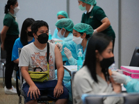 A health worker administers the COVID-19 vaccine to people at vaccination site inside the shopping mall in Bangkok on December 20, 2022 in B...