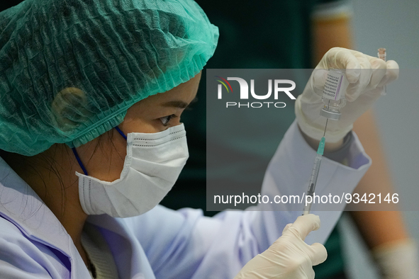 A health worker prepares syringes for administering the COVID-19 vaccine at vaccination site inside the shopping mall in Bangkok on December...