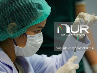 A health worker prepares syringes for administering the COVID-19 vaccine at vaccination site inside the shopping mall in Bangkok on December...