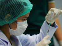 A health worker prepares syringes for administering the COVID-19 vaccine at vaccination site inside the shopping mall in Bangkok on December...