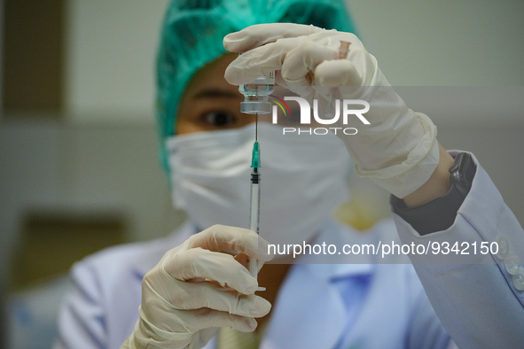 A health worker prepares syringes for administering the COVID-19 vaccine at vaccination site inside the shopping mall in Bangkok on December...