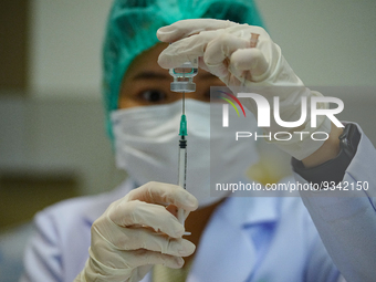 A health worker prepares syringes for administering the COVID-19 vaccine at vaccination site inside the shopping mall in Bangkok on December...