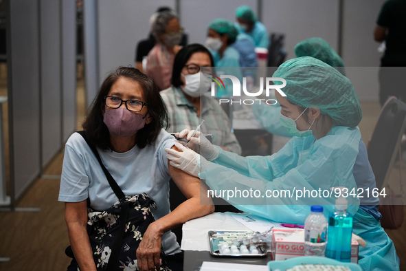 A health worker administers the COVID-19 vaccine to people at vaccination site inside the shopping mall in Bangkok on December 20, 2022 in B...