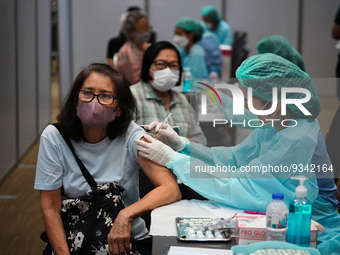 A health worker administers the COVID-19 vaccine to people at vaccination site inside the shopping mall in Bangkok on December 20, 2022 in B...