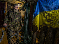 A soldier of a cossack battalion exhibits the ceremonial swords in the underground base of his unit near the frontlines of Zaporizhia region...
