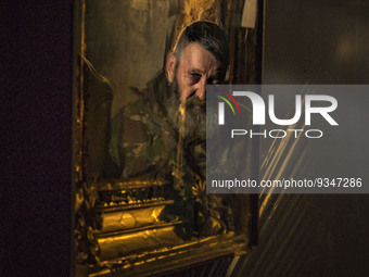 An orthodox icon reflects the face of an ukrainian soldier in his underground shelter while he waits during a russian shelling in Zaporizhia...