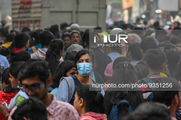 A lady is seen wearing mask at a crowded market in Kolkata , India , on 22 December 2022 . Indian health administration has issued fresh gui...