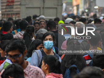 A lady is seen wearing mask at a crowded market in Kolkata , India , on 22 December 2022 . Indian health administration has issued fresh gui...