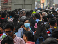 A lady is seen wearing mask at a crowded market in Kolkata , India , on 22 December 2022 . Indian health administration has issued fresh gui...