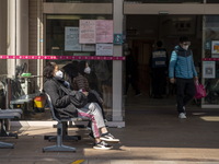 People sitting at the entrance for the emergency room at Kiang Wu Hospital on December 29, 2022 in Macau, China. (