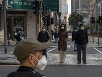 Pedestrian wearing face masks waiting to cross the street on December 29, 2022 in Macau, China. (