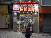 A man walks pass an open pharmacy store next to closed stores on December 29, 2022 in Macau, China. (