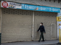 A man wearing a face mask walks pass a closed store on December 29, 2022 in Macau, China. (