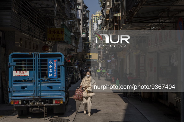 A women wearing a face mask walks downs a street on December 29, 2022 in Macau, China. 