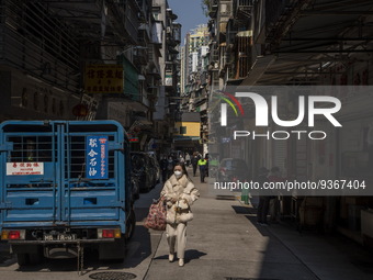 A women wearing a face mask walks downs a street on December 29, 2022 in Macau, China. (