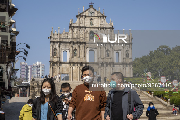 People wearing Face Mask walks pass the Ruins of St. Paul's on December 29, 2022 in Macau, China. 