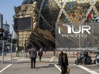 Pedestrian wearing face masks walks pass a street in front of the Grand Lisboa Hotel on December 29, 2022 in Macau, China. (