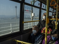 Commuters wearing face masks while riding on a bus on December 29, 2022 in Macau, China. (