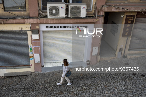 A women walks pass closed stores near the Ruins of St. Paul's on December 29, 2022 in Macau, China. 