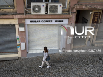 A women walks pass closed stores near the Ruins of St. Paul's on December 29, 2022 in Macau, China. (