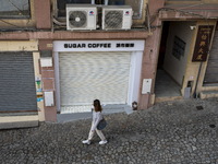 A women walks pass closed stores near the Ruins of St. Paul's on December 29, 2022 in Macau, China. (