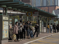 Commuters wearing face masks while waiting for a bus at a bus stop on December 29, 2022 in Macau, China. (