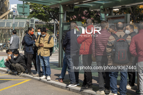 Commuters wearing face masks while waiting for a bus at a bus stop on December 29, 2022 in Macau, China. 