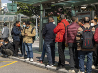 Commuters wearing face masks while waiting for a bus at a bus stop on December 29, 2022 in Macau, China. (