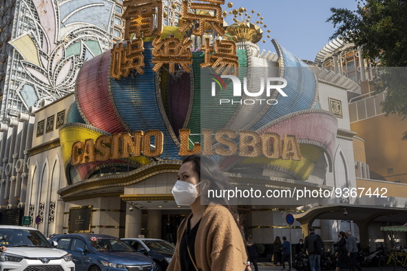 A women wearing a face mask walks pass the Casino Lisboa on December 29, 2022 in Macau, China. 