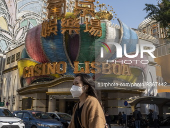 A women wearing a face mask walks pass the Casino Lisboa on December 29, 2022 in Macau, China. (