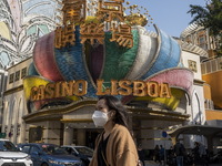 A women wearing a face mask walks pass the Casino Lisboa on December 29, 2022 in Macau, China. (