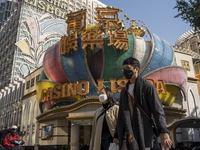 People wearing face masks walks pass the Casino Lisboa on December 29, 2022 in Macau, China. (