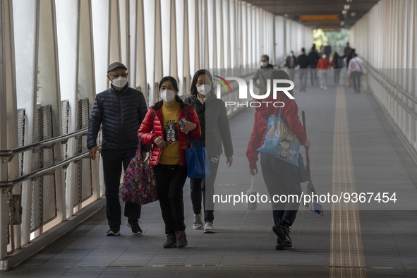 People wearing face masks while walking on a footbridge on December 29, 2022 in Macau, China. 