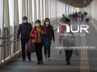 People wearing face masks while walking on a footbridge on December 29, 2022 in Macau, China. (