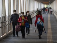 People wearing face masks while walking on a footbridge on December 29, 2022 in Macau, China. (