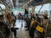 Commuters wearing face masks riding on the Macao Light Rapid Transit on December 29, 2022 in Macau, China. (