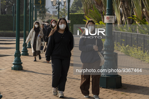 People wearing face masks walking in the street on December 29, 2022 in Macau, China. 