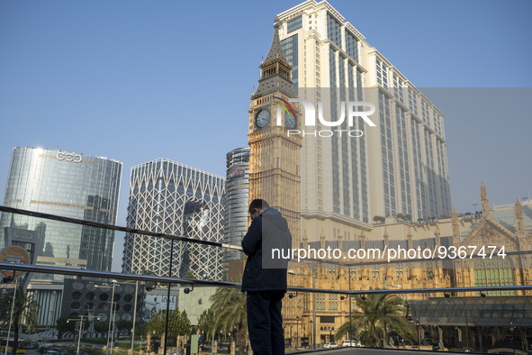 A man standing front of hotels , resorts and Casinos on the Cotai Strop on December 29, 2022 in Macau, China. 