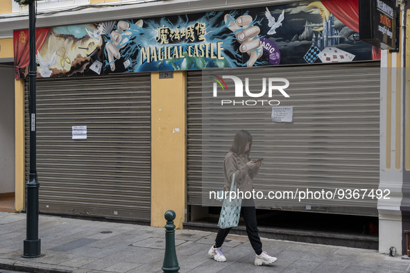 A woman wearing a face mask walks pass a closed store on December 29, 2022 in Macau, China. 