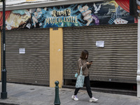 A woman wearing a face mask walks pass a closed store on December 29, 2022 in Macau, China. (