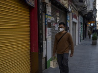 A man wearing a face mask walks pass closed stores on December 29, 2022 in Macau, China. (