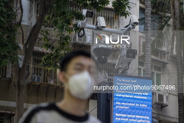 A man wearing face mask walks in front of a dozen of CCTV Camera on December 29, 2022 in Macau, China. 