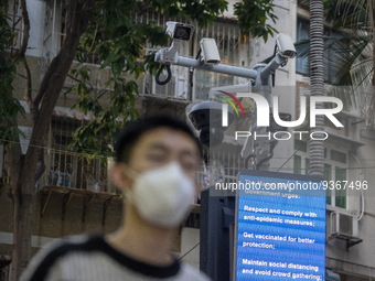 A man wearing face mask walks in front of a dozen of CCTV Camera on December 29, 2022 in Macau, China. (