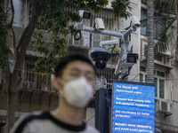 A man wearing face mask walks in front of a dozen of CCTV Camera on December 29, 2022 in Macau, China. (