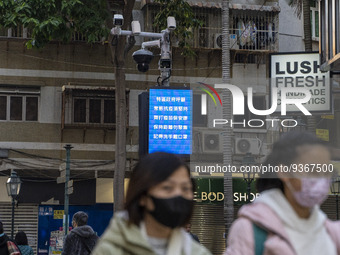 People wearing face masks in front of a dozen of CCTV Camera on December 29, 2022 in Macau, China. (